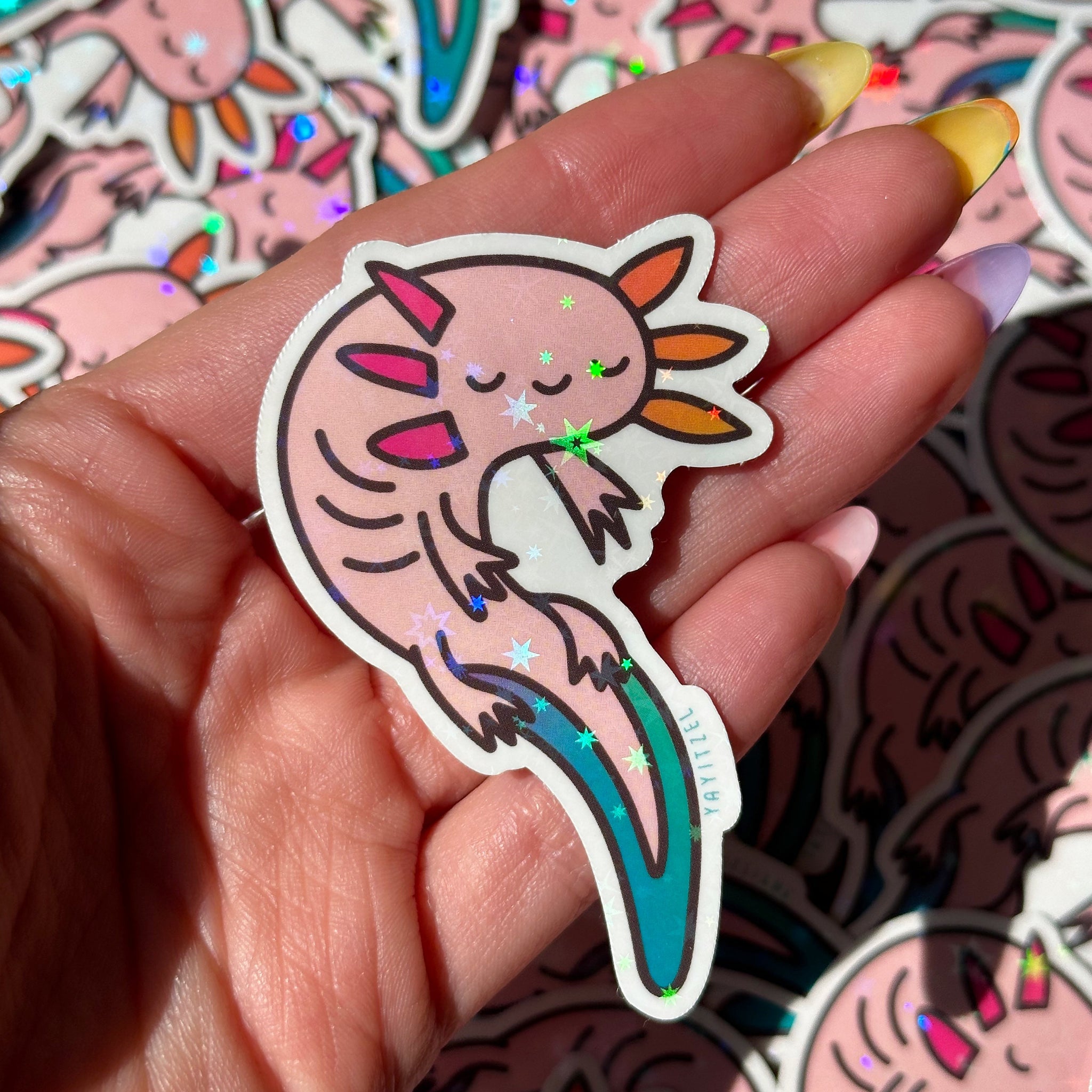 holding one colorful axolotl holographic sticker. it has holographic foil that sparkles in the shape of stars