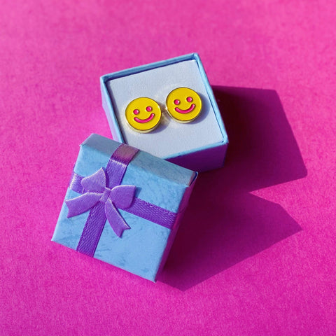 smiley earrings sitting in small gift box, gift box lid has a tiny bow on top and is leaning on box